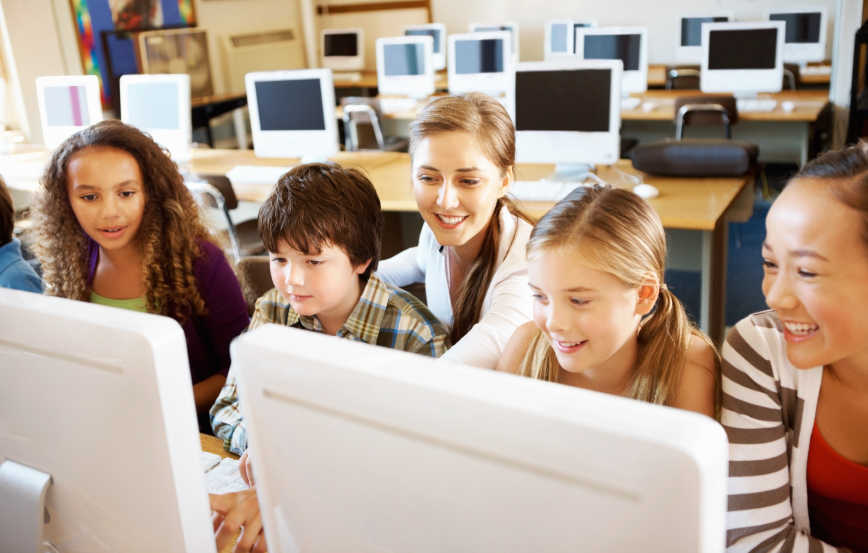 Group of multi racial students at computer class with their teacher